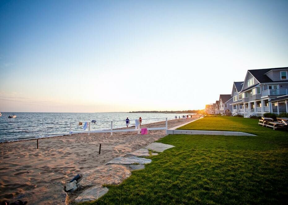 Homes on the shore in Connecticut with the sun setting in the background.