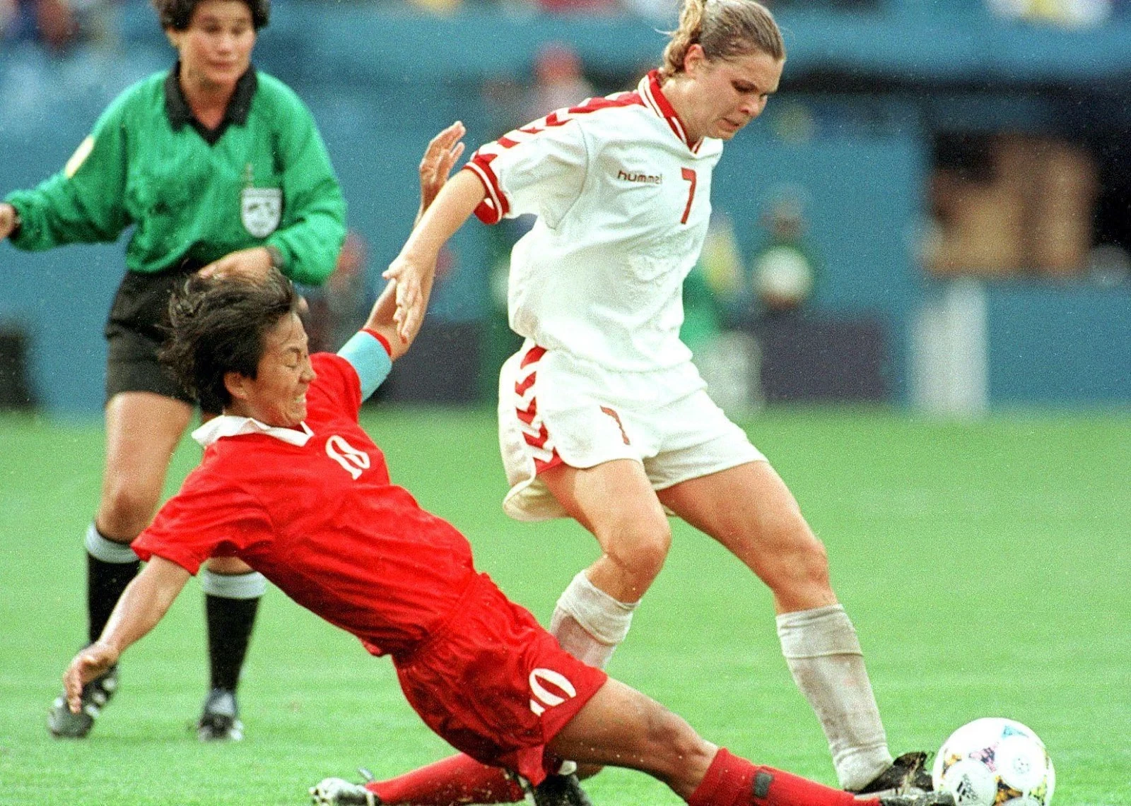 Kim Sun Hui of North Korea kicks the ball away from Louise Hansen.