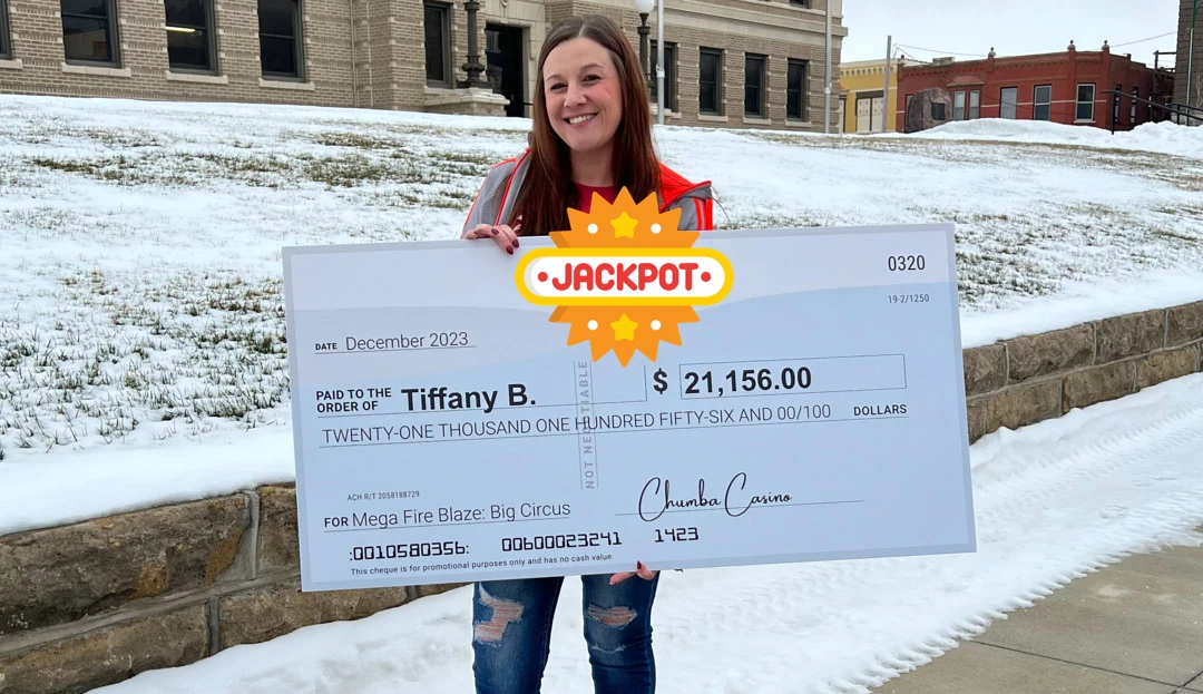 Tiffany B. holding a check with the amount of money she won playing casino games online.