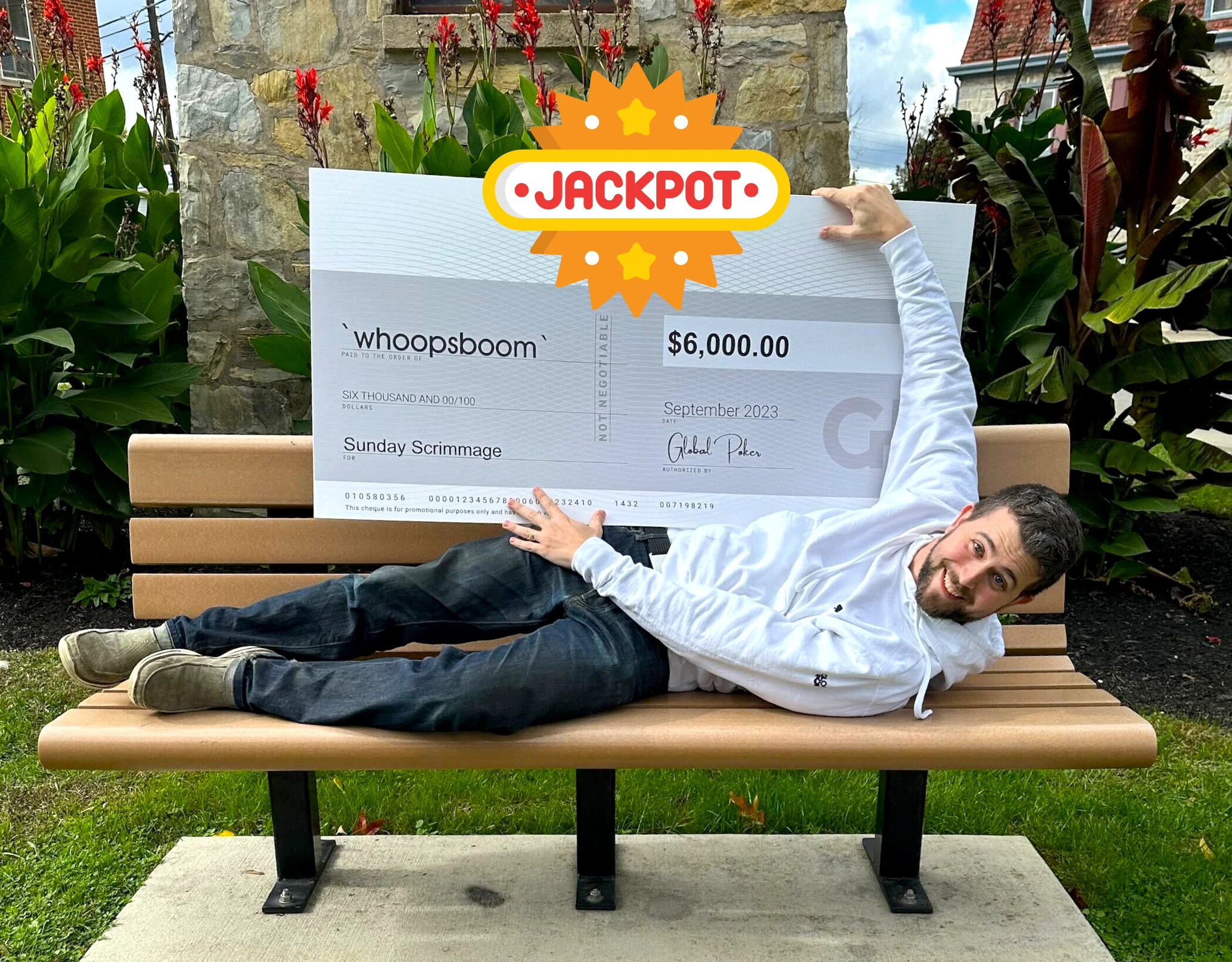 Play WhoopsBoom laying on a bench holding a check with the amount of money he won playing casino games online.